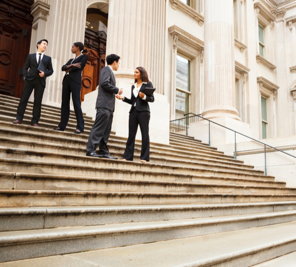 Four people standing on marble steps