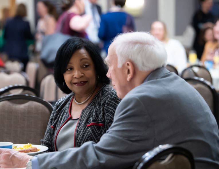 Two trial lawyers meeting about a case during a convention.